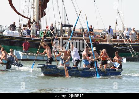 West Mersea, Großbritannien. 13. August 2022. Die West Mersea Regatta findet auf Mersea Island statt. Die Regatta wird seit 1838 fast ununterbrochen durchgeführt und wird von Freiwilligen organisiert. Das Sturmschiff (Dory)-Rennen. Kredit: Eastern Views/Alamy Live Nachrichten Stockfoto