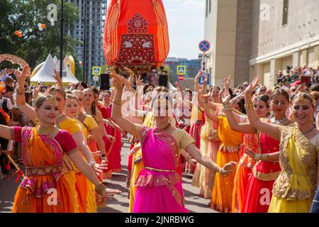 Moskau, Russland. 13. vom August 2022. Eine Menge Anhänger marschieren mit dem Hauptwagen während der Feier der Ratha Yatra Parade oder des Hindu Religious Chariot Festivals, als Teil des India Day Festivals im Dream Island Park, Russland Stockfoto