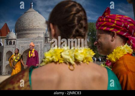 Moskau, Russland. 13. vom August 2022. Russische Paare, die nationale indische Kostüme tragen, werden vor dem Hintergrund eines Banners mit einem Bild des Taj Mahal während des India Day Festivals fotografiert, das im Dream Island Park in Moskau, Russland, stattfindet Stockfoto