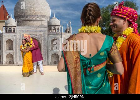 Moskau, Russland. 13. vom August 2022. Russische Paare, die nationale indische Kostüme tragen, werden vor dem Hintergrund eines Banners mit einem Bild des Taj Mahal während des India Day Festivals fotografiert, das im Dream Island Park in Moskau, Russland, stattfindet Stockfoto