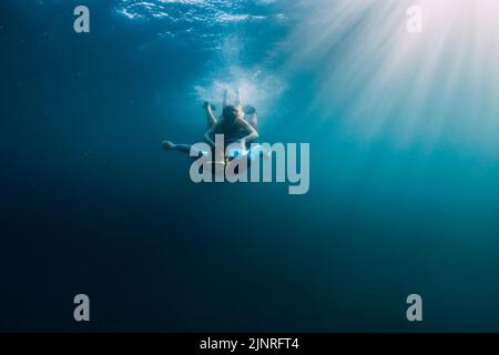 07. August 2021. Varna, Bulgarien. Männer Freitaucher mit Flossen in blauem Meer und Sonnenstrahlen. Freitauchend unter Wasser in transparentem Meer Stockfoto