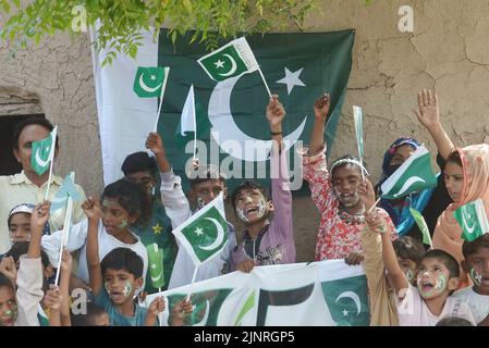 Die Kinder und Arbeiter der United Social Welfare Society von pakistanischen Ziegelöfen feiern den Unabhängigkeitstag 75. am Ziegelofen in Lahore. Der Unabhängigkeitstag (Y?um-e-?z?di), der jährlich am 14. August begangen wird, ist ein Nationalfeiertag in Pakistan. Es erinnert an den Tag, an dem Pakistan seine Unabhängigkeit erlangte und nach dem Ende des britischen Raj im Jahr 1947 zum souveränen Staat erklärt wurde. Pakistan entstand durch die Pakistan-Bewegung, die die Schaffung eines unabhängigen muslimischen Staates in den nordwestlichen Regionen des britischen Indiens durch Teilung anstrebte. Die Bewegung Stockfoto