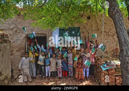 Die Kinder und Arbeiter der United Social Welfare Society von pakistanischen Ziegelöfen feiern den Unabhängigkeitstag 75. am Ziegelofen in Lahore. Der Unabhängigkeitstag (Y?um-e-?z?di), der jährlich am 14. August begangen wird, ist ein Nationalfeiertag in Pakistan. Es erinnert an den Tag, an dem Pakistan seine Unabhängigkeit erlangte und nach dem Ende des britischen Raj im Jahr 1947 zum souveränen Staat erklärt wurde. Pakistan entstand durch die Pakistan-Bewegung, die die Schaffung eines unabhängigen muslimischen Staates in den nordwestlichen Regionen des britischen Indiens durch Teilung anstrebte. Die Bewegung Stockfoto