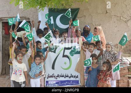 Die Kinder und Arbeiter der United Social Welfare Society von pakistanischen Ziegelöfen feiern den Unabhängigkeitstag 75. am Ziegelofen in Lahore. Der Unabhängigkeitstag (Y?um-e-?z?di), der jährlich am 14. August begangen wird, ist ein Nationalfeiertag in Pakistan. Es erinnert an den Tag, an dem Pakistan seine Unabhängigkeit erlangte und nach dem Ende des britischen Raj im Jahr 1947 zum souveränen Staat erklärt wurde. Pakistan entstand durch die Pakistan-Bewegung, die die Schaffung eines unabhängigen muslimischen Staates in den nordwestlichen Regionen des britischen Indiens durch Teilung anstrebte. Die Bewegung Stockfoto