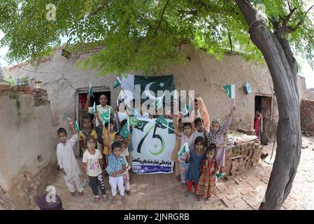 Die Kinder und Arbeiter der United Social Welfare Society von pakistanischen Ziegelöfen feiern den Unabhängigkeitstag 75. am Ziegelofen in Lahore. Der Unabhängigkeitstag (Y?um-e-?z?di), der jährlich am 14. August begangen wird, ist ein Nationalfeiertag in Pakistan. Es erinnert an den Tag, an dem Pakistan seine Unabhängigkeit erlangte und nach dem Ende des britischen Raj im Jahr 1947 zum souveränen Staat erklärt wurde. Pakistan entstand durch die Pakistan-Bewegung, die die Schaffung eines unabhängigen muslimischen Staates in den nordwestlichen Regionen des britischen Indiens durch Teilung anstrebte. Die Bewegung Stockfoto