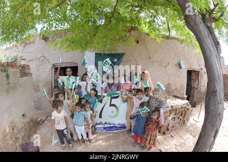 Die Kinder und Arbeiter der United Social Welfare Society von pakistanischen Ziegelöfen feiern den Unabhängigkeitstag 75. am Ziegelofen in Lahore. Der Unabhängigkeitstag (Y?um-e-?z?di), der jährlich am 14. August begangen wird, ist ein Nationalfeiertag in Pakistan. Es erinnert an den Tag, an dem Pakistan seine Unabhängigkeit erlangte und nach dem Ende des britischen Raj im Jahr 1947 zum souveränen Staat erklärt wurde. Pakistan entstand durch die Pakistan-Bewegung, die die Schaffung eines unabhängigen muslimischen Staates in den nordwestlichen Regionen des britischen Indiens durch Teilung anstrebte. Die Bewegung Stockfoto