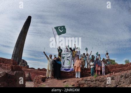 Die Kinder und Arbeiter der United Social Welfare Society von pakistanischen Ziegelöfen feiern den Unabhängigkeitstag 75. am Ziegelofen in Lahore. Der Unabhängigkeitstag (Y?um-e-?z?di), der jährlich am 14. August begangen wird, ist ein Nationalfeiertag in Pakistan. Es erinnert an den Tag, an dem Pakistan seine Unabhängigkeit erlangte und nach dem Ende des britischen Raj im Jahr 1947 zum souveränen Staat erklärt wurde. Pakistan entstand durch die Pakistan-Bewegung, die die Schaffung eines unabhängigen muslimischen Staates in den nordwestlichen Regionen des britischen Indiens durch Teilung anstrebte. Die Bewegung Stockfoto