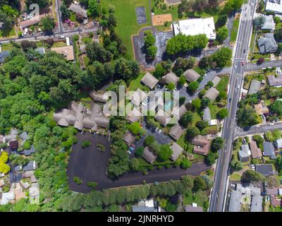 Blick von oben auf eine kleine schöne Stadt. Viel Grün, kleine einstöckige Häuser, asphaltierte Straßen und Wanderwege. Karte, Planung, Umwelt und Soziales Stockfoto
