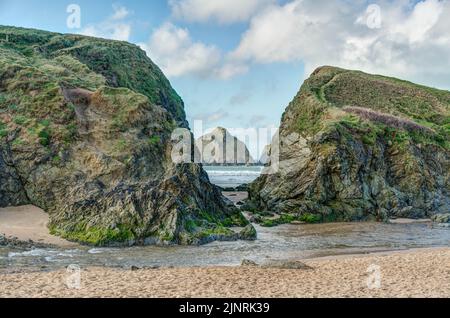 Holywell Bay in der Wintersonne, beliebt für seine riesigen Gras bewachsenen Sanddünen und großen vorgelagerten felsigen Inseln, die vom schönen Sandstrand aus gesehen werden. Stockfoto