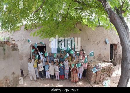 Lahore, Punjab, Pakistan. 12. August 2022. Die Kinder und Arbeiter der United Social Welfare Society von pakistanischen Ziegelöfen feiern den Unabhängigkeitstag 75. am Ziegelofen in Lahore. Der Unabhängigkeitstag (Y?um-e-?z?di), der jährlich am 14. August begangen wird, ist ein Nationalfeiertag in Pakistan. Es erinnert an den Tag, an dem Pakistan seine Unabhängigkeit erlangte und nach dem Ende des britischen Raj im Jahr 1947 zum souveränen Staat erklärt wurde. Pakistan entstand durch die Pakistan-Bewegung, die auf die Schaffung eines unabhängigen muslimischen Staates in den nordwestlichen Regionen abzielte Stockfoto