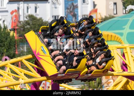 Menschen auf der Rage Thrill Ride von Adventure Island in Southend on Sea, Essex, Großbritannien, an einem hellen, sonnigen Tag während der Sommerhitze 2022 Stockfoto
