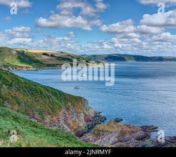 Blick vom South West Coastal Path in der Nähe von Hendersick nach Osten in Richtung Hannafore und Looe, einer wunderschönen natürlichen zerklüfteten Küste an einem schönen Tag Stockfoto