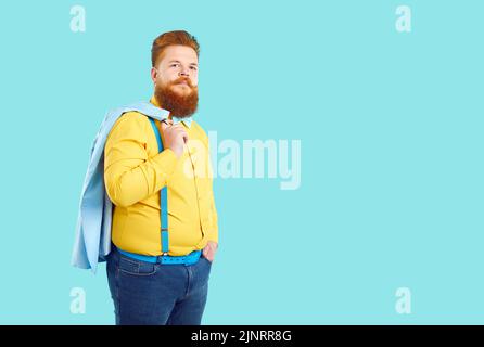 Rotschopf kaukasischer Mann mit Bart und Schnurrbart trägt gelbes Hemd und Jeans steht im Studio Stockfoto