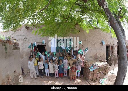 Lahore, Punjab, Pakistan. 12. August 2022. Die Kinder und Arbeiter der United Social Welfare Society von pakistanischen Ziegelöfen feiern den Unabhängigkeitstag 75. am Ziegelofen in Lahore. Der Unabhängigkeitstag (Y?um-e-?z?di), der jährlich am 14. August begangen wird, ist ein Nationalfeiertag in Pakistan. Es erinnert an den Tag, an dem Pakistan seine Unabhängigkeit erlangte und nach dem Ende des britischen Raj im Jahr 1947 zum souveränen Staat erklärt wurde. Pakistan entstand durch die Pakistan-Bewegung, die auf die Schaffung eines unabhängigen muslimischen Staates in den nordwestlichen Regionen abzielte Stockfoto