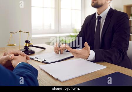 Rechtsanwalt oder Rechtsberater, der am Schreibtisch sitzt und über Vertragsvereinbarung mit dem Kunden spricht Stockfoto