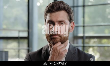 Nachdenklich kaukasischen bärtigen 40s Geschäftsmann denken Lösung Geschäftsproblem nachdenklich männlichen professionellen im Büro denken. Fokussierter CEO-Chef Stockfoto