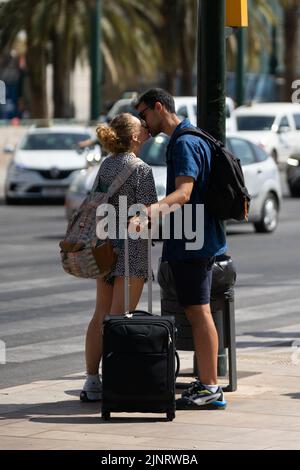 Malaga, Spanien. 11. August 2022. Ein Paar mit einem Koffer sah sich am ersten Tag der Messe von Malaga 2022 küssen. Die Messe findet zum ersten Mal seit 2019 statt. Die Ausgaben 2020 und 2021 wurden aufgrund einer Pandemie von Covid19 ausgesetzt. (Foto von Francis Gonzalez/SOPA Images/Sipa USA) Quelle: SIPA USA/Alamy Live News Stockfoto