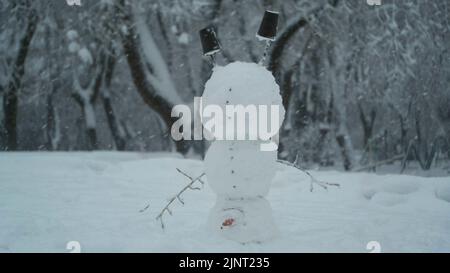 13. August 2022, Oblast Odessa, Ukraine, Osteuropa: Fröhlicher, lustiger Schneemann-akrobatin, der auf dem Kopf steht, vor dem Hintergrund eines starken Schneefalls. Schneemann steht auf seinem Kopf (Bild: © Andrey Nekrasov/ZUMA Press Wire) Stockfoto