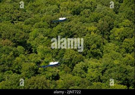 UH-1N Huey Heliopter, die dem ersten Helicopter Squadron, Joint Base Andrews, MD., zugewiesen wurden, fliegen während des Trainings in Formation über Maryland, 9. August 2022. 1 die Mission von HS besteht darin, eine vorrangige Luftbrücke für hochrangige zivile und militärische Führungskräfte auf nationaler Ebene in der Region der Hauptstadt zu schaffen. (USA Luftwaffe Foto von Master Sgt. Nicholikpriester) Stockfoto