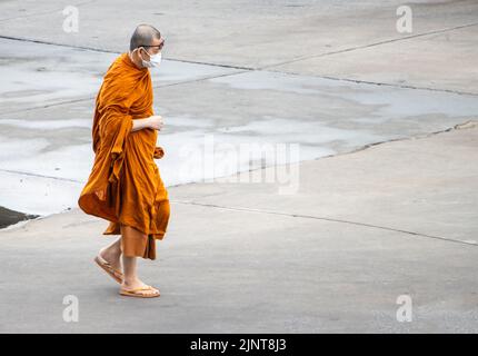 SAMUT PRAKAN, THAILAND, MAI 28 2022, buddhistischer Mönch läuft auf nassem Beton Stockfoto