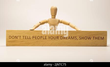 Das Wort sagt den Menschen nicht eure Träume, zeigt ihnen, dass sie auf der hölzernen Oberfläche geschrieben wurden.Slogans und positives Denken Stockfoto