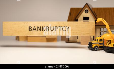 Insolvenz Wort auf Holzoberfläche geschrieben. Haus- und Baukonzept im Hintergrund. Hypothek und Wirtschaft Stockfoto