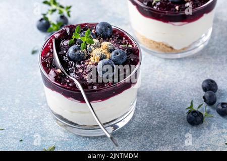 Heidelbeer-Käsekuchen in einem Glas mit graham-Cracker-Basis Stockfoto