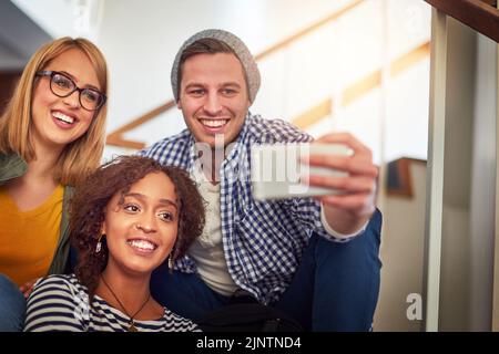 Die Freunde, die du machst, werden deine Freunde fürs Leben. Eine Gruppe von Studenten, die ein Selfie auf dem Campus machen. Stockfoto