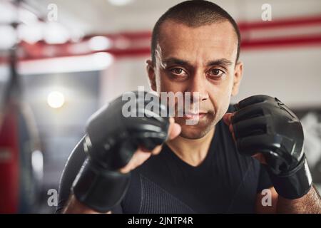 Im Kampf geht es um Technik. Beschnittenes Porträt eines professionellen Kampftrainings in der Turnhalle. Stockfoto