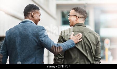 Unterstützung, Vertrauen und Motivation zwischen Freunden, Mitarbeitern und Gelegenheitsmännern, die sich während des Spazierens in der Stadt über eine Jobmöglichkeit oder Beförderung freuen Stockfoto