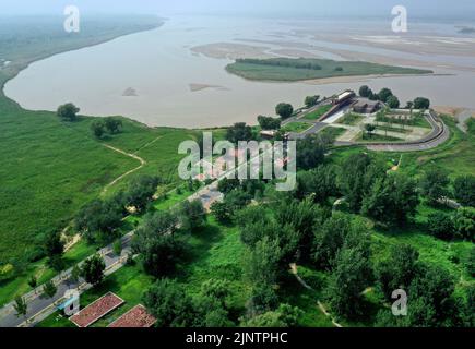 (220814) -- SANMENXIA, 14. August 2022 (Xinhua) -- Luftfoto vom 11. August 2022 zeigt einen Park am Gelben Fluss in der Stadt Zhengzhou, der zentralchinesischen Provinz Henan. Der 711 Kilometer lange Henan-Abschnitt des Gelben Flusses fließt durch die wichtigste Wirtschaftszone Zentralchinas. In den letzten Jahren baut die Provinz Henan den ökologischen Korridor entlang des Gelben Flusses weiter und integriert Funktionen wie Hochwasserschutz, Lebensräume für Pflanzen und Tiere, ökologische Landwirtschaft und Kulturtourismus. Rund 7.513 Hektar Grünfläche wurden entlang des Henan-Abschnitts des Gelben Rivs fertiggestellt Stockfoto