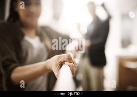 Geschäftliche Konkurrenz, Rivalität oder Herausforderung einer Frau, die im Büro an einem Seil zieht. Berufstätige, die einen Streit in einem Unternehmen oder am Arbeitsplatz haben Stockfoto