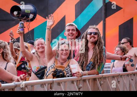 Viele Jugendliche in Kostümen sahen auf dem Fair Festival singen und tanzen. Boomtown Festival - Kapitel 1: The Gathering - findet im Matterley Estate, in der Nähe von Winchester, Hampshire, statt und wird von Mittwoch, 10.. Bis Sonntag, 14.. August 2022, stattfinden. Boomtown folgt einer Geschichte, die sich jedes Jahr entwickelt und für die Welt nach der Pandemie zurückgesetzt wurde, in der der Ausnahmezustand zu einem Zustand des Aufbruchs wurde, der aus der Asche des Alten auferstanden ist. Es ist eine neue Welt, begleitet von einer neuen Geschichte, die darauf wartet, erzählt zu werden, die sich auf Reflexion, Akzeptanz und Wiederverbindung konzentriert. Es ist eine Zeit von Stockfoto