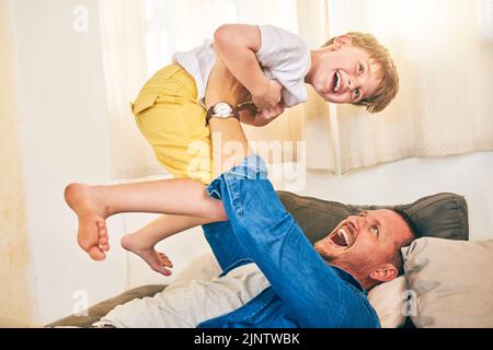 Mehr als Spielzeit, seine Bindungszeit. Ein glücklicher kleiner Junge, der Spaß mit seinem Vater zu Hause hat. Stockfoto