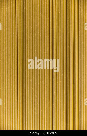 Italienische gesunde Lebensmittel Hintergrund, rohe Spinat Spaghetti füllen den Rahmen in einem strukturierten Design aus grünen vertikalen Pasta-Linien. Stockfoto