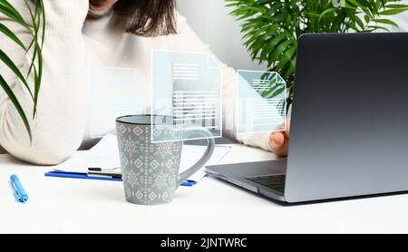 Frau sitzt an einem Tisch und arbeitet an einem Laptop, dem Rekrutierungsprozess. Auswahl talentierter Mitarbeiter, Karriereentwicklung Stockfoto