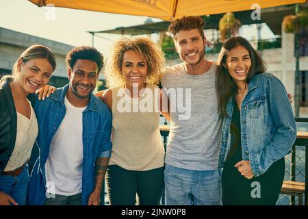 Dachfeste mit den besten Menschen. Porträt einer Gruppe junger, vielfältiger Freunde, die den Tag draußen auf einem Dach verbringen. Stockfoto