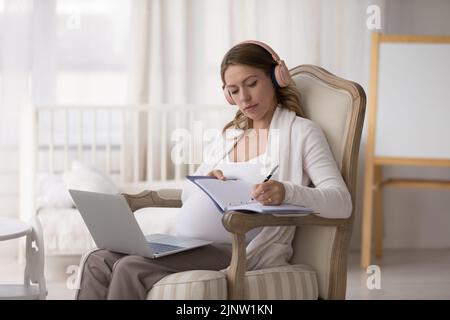 Schwangere verwenden Laptop Online-Beratung erhalten, schreibt hilfreiche Informationen Stockfoto