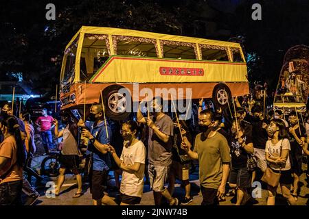 Kuala Lumpur, Malaysia. 13. August 2022. Malaysische Chinesen tragen während des chinesischen Hungry Ghost Festivals Joss Sticks und einen Bus aus Papier. Nach taoistischem und buddhistischem Glauben ist der siebte Monat des chinesischen Mondkalenders, bekannt als Hungry Ghost Festival, der Zeitpunkt, an dem sich die Tore der Hölle öffnen, um Geister auszulassen, die das Land der Lebenden auf der Suche nach Nahrung durchstreifen. Speiseopfer werden gemacht, während Papiergeld und Joss-Sticks verbrannt werden, um die Geister toter Vorfahren glücklich zu halten und Viel Glück. zu bringen Kredit: SOPA Images Limited/Alamy Live Nachrichten Stockfoto