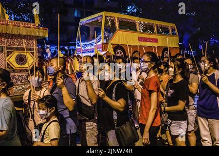 Kuala Lumpur, Malaysia. 13. August 2022. Malaysische Chinesen tragen während des chinesischen Hungry Ghost Festivals Joss Sticks vor einem Papierbus. Nach taoistischem und buddhistischem Glauben ist der siebte Monat des chinesischen Mondkalenders, bekannt als Hungry Ghost Festival, der Zeitpunkt, an dem sich die Tore der Hölle öffnen, um Geister auszulassen, die das Land der Lebenden auf der Suche nach Nahrung durchstreifen. Speiseopfer werden gemacht, während Papiergeld und Joss-Sticks verbrannt werden, um die Geister toter Vorfahren glücklich zu halten und Viel Glück. zu bringen Kredit: SOPA Images Limited/Alamy Live Nachrichten Stockfoto