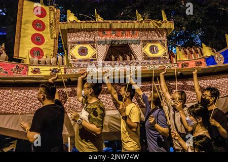 Kuala Lumpur, Malaysia. 13. August 2022. Malaysische Chinesen tragen während des chinesischen Hungry Ghost Festivals Joss Sticks und einen Bus aus Papier. Nach taoistischem und buddhistischem Glauben ist der siebte Monat des chinesischen Mondkalenders, bekannt als Hungry Ghost Festival, der Zeitpunkt, an dem sich die Tore der Hölle öffnen, um Geister auszulassen, die das Land der Lebenden auf der Suche nach Nahrung durchstreifen. Speiseopfer werden gemacht, während Papiergeld und Joss-Sticks verbrannt werden, um die Geister toter Vorfahren glücklich zu halten und Viel Glück. zu bringen Kredit: SOPA Images Limited/Alamy Live Nachrichten Stockfoto