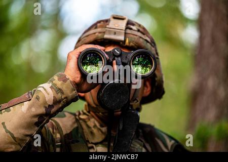 Niinisalo, Finnland. 28.. Juli 2022. Ein US-Soldat mit 4. Squadron, 10. Kavallerie-Regiment, 3. Panzerbrigade-Kampfteam, 4. Infanterie-Division, verwendet Ferngläser an einem Beobachtungsposten während der Vigilant Fox, einer gemeinsamen Übung, bei der finnische Soldaten, US-Soldaten und britische Soldaten, die dem 2. Bataillon, Gewehre-Regiment, in Niinisalo, Finnland, zugewiesen wurden, 28. Juli, 2022. Der 3/4. ABCT ist unter anderem der 1. Infanterie-Division zugeordnet und arbeitet stolz mit NATO-Verbündeten und regionalen Sicherheitspartnern zusammen, um dem V Corps, Amerikas vorwärts entsandt Korps, kampfglaubwürdige Streitkräfte zur Verfügung zu stellen Stockfoto