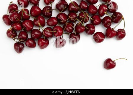 Rahmen von reifen Süßkirschen mit leerem Raum für Text isoliert auf weißem Hintergrund, Gruppe von roten Beeren, Draufsicht Stockfoto