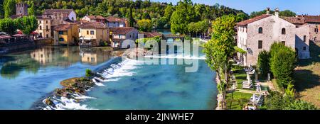 Borghetto sul Mincio - eines der schönsten mittelalterlichen Dörfer Italiens. Bunte Häuser in der Mitte des Flusses und Wasserfälle. Verona provin Stockfoto