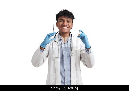 Junger peruanischer Arzt lächelt und hält eine Spritze und eine Ampulle, isoliert. Stockfoto