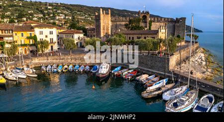 Malerische Orte des schönen Lago di Garda See. Luftaufnahme des charmanten Dorfes Torri del Benaco und mittelalterliche Burg. Italien, Provinz Verona Stockfoto