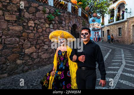 Ein junges mexikanisches Paar, bekleidet als La Catrina und Catrin, nimmt an den Feierlichkeiten zum Tag der Toten in Taxco de Alarcón, Guerrero, Mexiko, Teil. Stockfoto