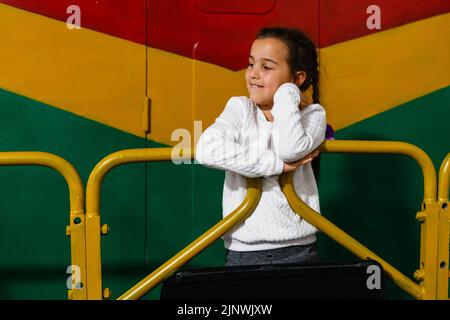 Ein kleines Mädchen in der Nähe eines großen Waggons Stockfoto