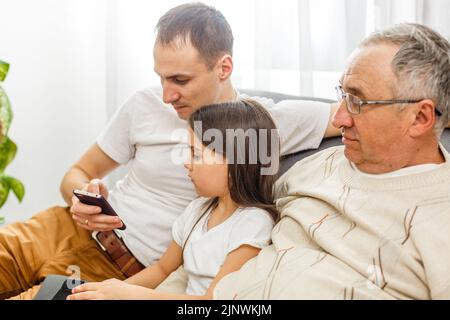 Großer glücklicher Familienvater mit mehreren Generationen, ältere Großeltern mit niedlichen kleinen Mädchen Enkelin zu Hause. Familie und Liebe Konzept Stockfoto