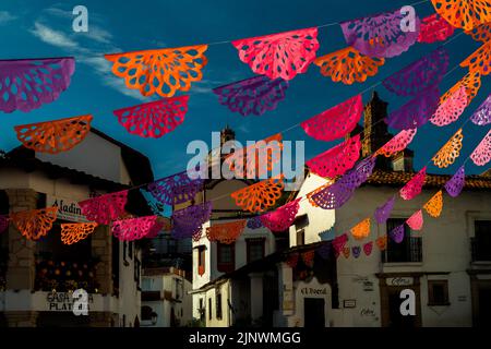 Auf dem kolonialen platz werden während der Feierlichkeiten zum Tag der Toten in Taxco de Alarcón, Guerrero, Mexiko, gepeckte Papierfahnen aufgehängt. Stockfoto